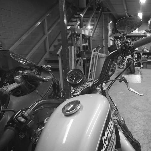 A black and white photo of 2 bikes in the garage